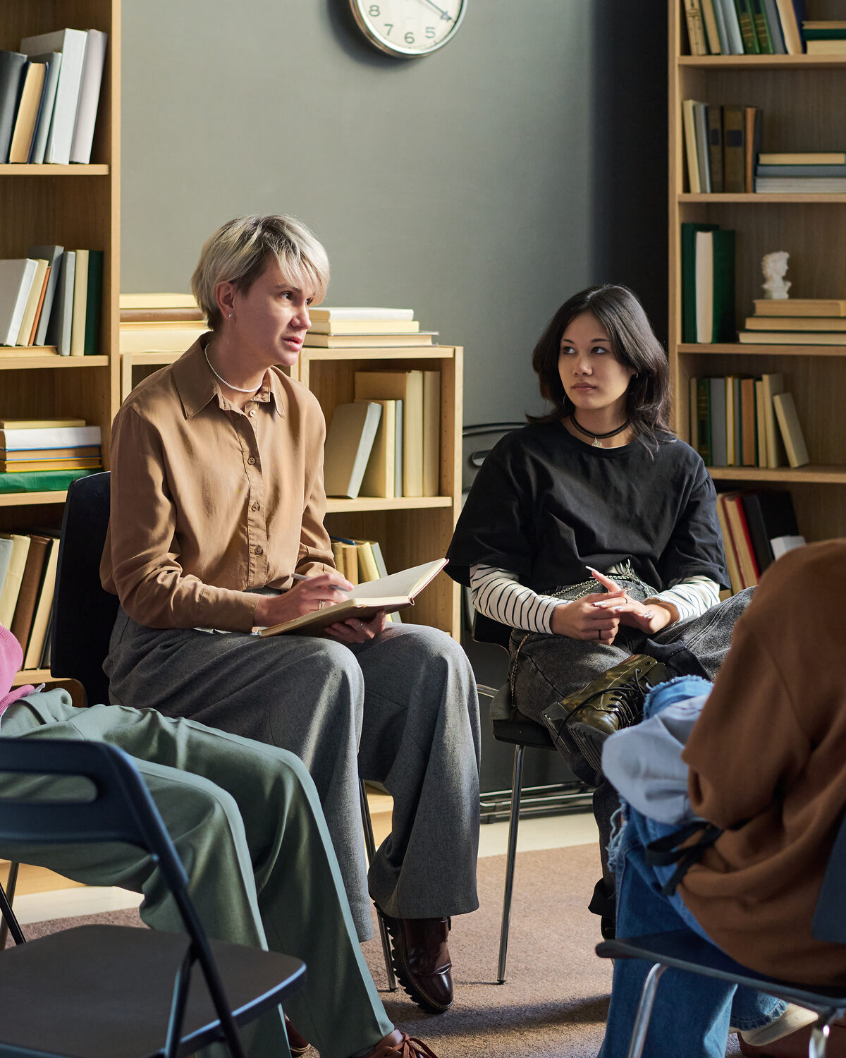 A small family group sitting together in a room with a clinician, talking through something.